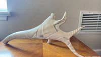Full side view of carved white antler sculpture on tabletop