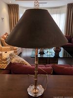 Full view of lamp on table showing body, base, shade