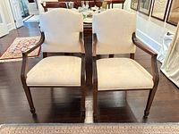 Front view of both armchairs showing upholstery, wood frames, overall condition