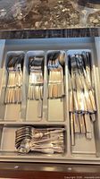 Full flatware tray showing grouped dinner forks, dinner knives, tablespoons, teaspoons