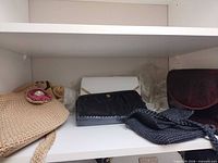 Shelf with five handbags showing variety of materials and colors