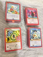 Four plastic-wrapped stacks of red-border MetaZoo cards displayed on fabric surface