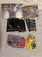 Full lot view showing postcard book, sealed Star Trek set, Spawn packs, Star Trek packs, loose Marvel cards