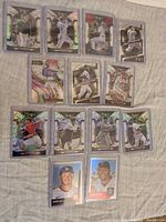 Full layout of 13 sleeved baseball cards, showing brands and holographic finishes