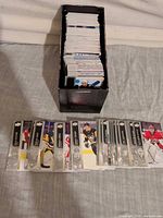 Top view of open storage box filled with hockey cards and spread of selected cards in front