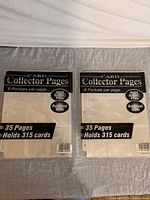 Two sealed packs of card collector pages side by side