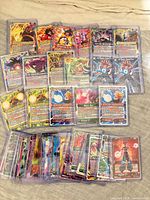 Spread of approximately 50 Dragon Ball Super cards in sleeves and toploaders