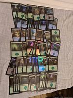 Spread of approximately 100 foil Forest, Island and Swamp basic land cards