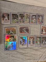 All 16 Topps baseball cards laid out showing both base and silver foil variants in top loaders