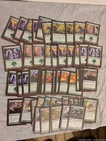 All sleeved green cards spread out, showing Forest lands and mixed spells