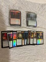 Two sealed sleeved stacks of cards plus array of foils laid out