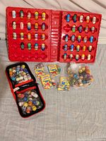 Open red display case filled with numerous Mighty Beanz, zip pouch, sealed packs and loose beans bag visible