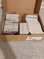 Cardboard box with two large stacks and one smaller stack of baseball cards