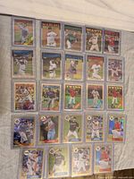 Full layout of 24 Topps Chrome refractor cards in sleeves and top-loaders