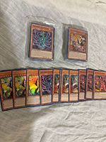 Two sleeved stacks and row of displayed holographic Yu-Gi-Oh! cards