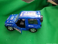 Side view of blue toy SUV showing decals and opening door