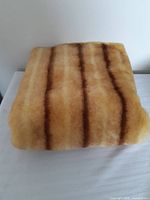 Folded striped faux fur fabric on white surface
