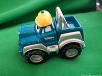 Front/side view of teal Tonka tow truck toy with yellow hard hat roof detail