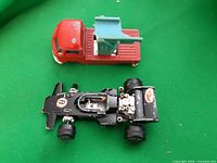 Top view of both diecast vehicles showing condition, missing wheel on Lotus, damaged attachment on pickup