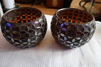 two spherical metal tea light holders side by side