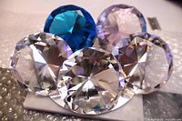 Front view of all five faceted glass diamonds showing colours and faceting