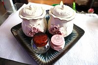Group shot showing both ceramic rose jars, Avon jars and tray