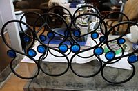 Front angled view of entire metal wine rack showing layout and glass inserts