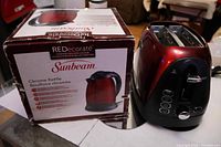Boxed Sunbeam kettle alongside Oster toaster
