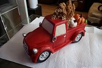 Left front angle of red pickup truck with harvest load visible