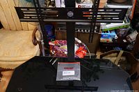 Front view showing vertical mount bracket, brand logo, and glass top