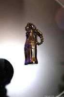 Full view of gold-tone Coca-Cola bottle key chain hanging
