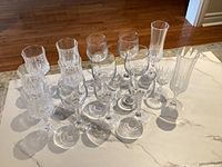 Group view of all 15 clear crystal stem glasses showing mixed shapes and cut patterns