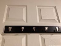 Black wood rack with five chrome hooks