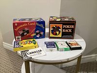 Overall lot showing boxed shuffler, poker rack, multiple decks and booklet