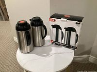 Two stainless steel Copco carafes beside original 2-pack box