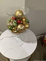 Vase filled with ornaments on small table, full view