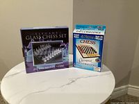 Two boxed chess sets side by side
