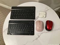 Top view showing two keyboards, two mice, EarPods in case