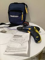 Drill/driver, carrying bag, charger, bits and manual grouped together