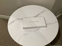 White Michael Kors branded box on tabletop
