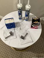 Entire lot on table: 2 faucet handles, 2 Dynaflex tubes, Grohe box, Philips bulb box