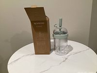 Tumbler beside open original box on table