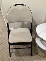 Front view of chair showing beige fabric upholstery and black frame
