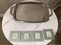 Top view of stainless steel tray with four coasters beneath