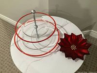 Overall view of glass two-tier stand alongside red poinsettia tray