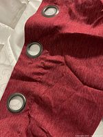 Close-up of red fabric with metal grommets