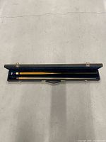 Open case showing two-piece pool cue