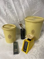 Group shot of all items: two canisters, grinder, scale, spoon in case