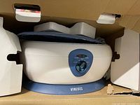 Homedics ParaSpa Deluxe unit within its carton, showing device and styrofoam inserts