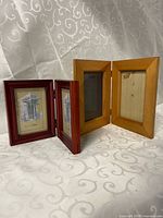 Both wooden double frames standing open to show colour difference and hinges